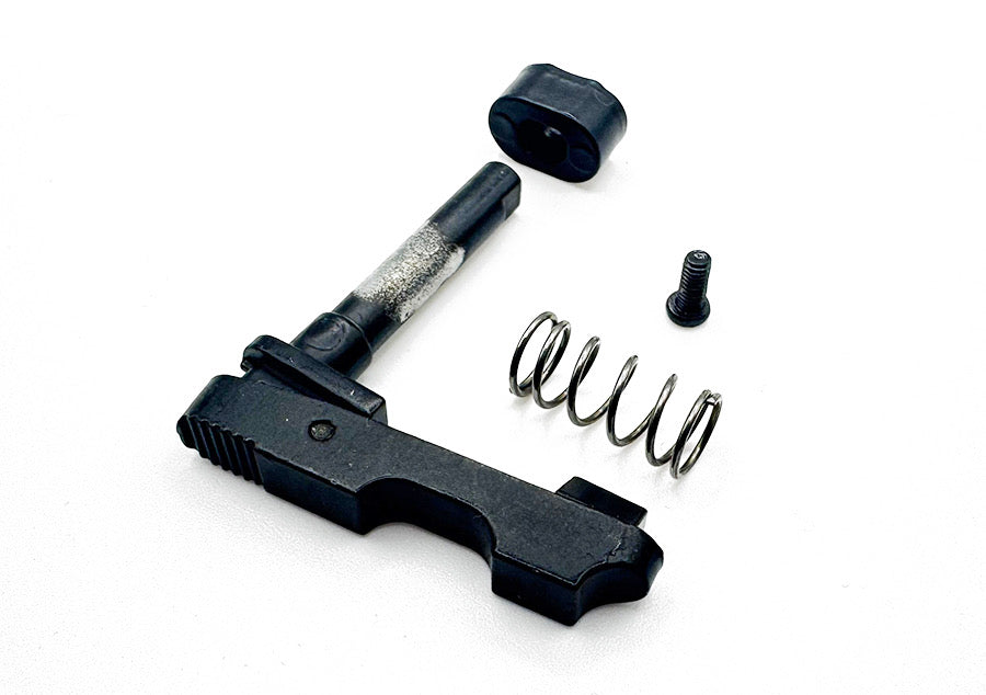 A black metal mechanical component, likely a firearm trigger assembly, shown disassembled with its spring, screw, and cap on a white background.