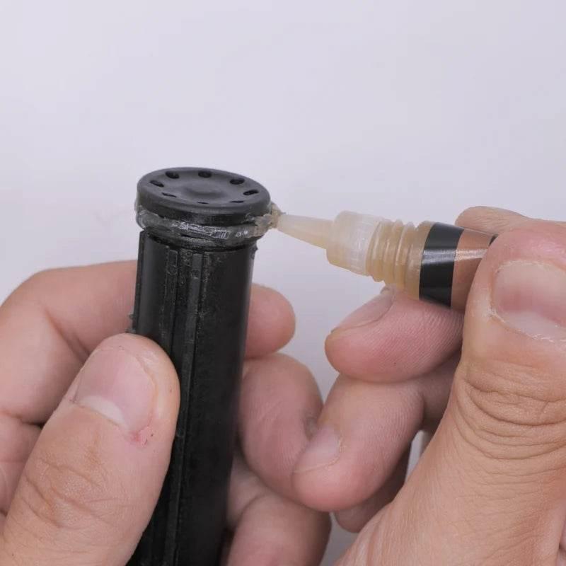 Person applying 4UANTUM ANTI-LEAK solution on the top of a black tube for sealing leaks