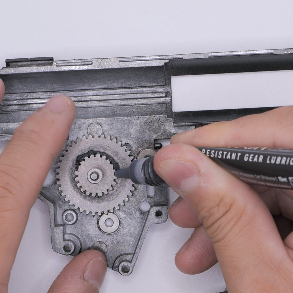 Applying 4UANTUM HEAT RESISTANT GEAR LUBRICANT to metal gears for optimal performance