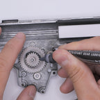 Applying 4UANTUM HEAT RESISTANT GEAR LUBRICANT to metal gears for optimal performance