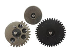 Three metal gear components on a plain white background: one large black gear, one smaller metallic gray gear with cutouts, and one small round metal piece.
