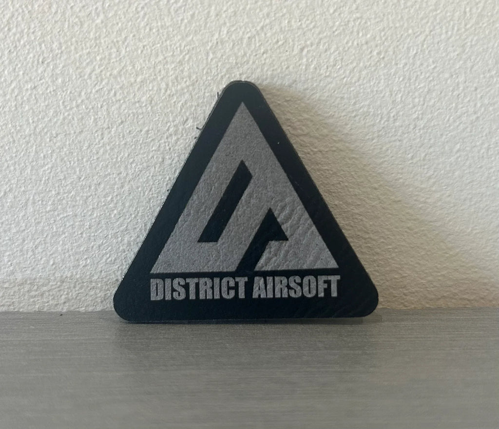 Triangle AIRSOFT DISTRICT PATCH with a black and silver design for airsoft enthusiasts