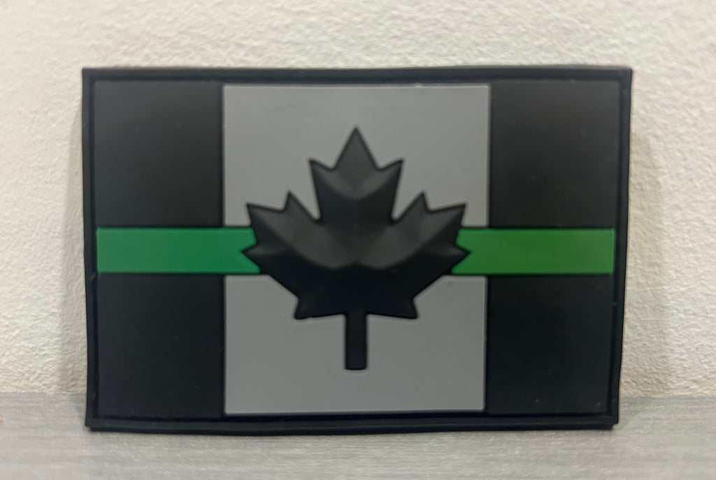 DISTRICT AIRSOFT Canada PVC Patch with Black Maple Leaf and Green Stripe on Gray Background