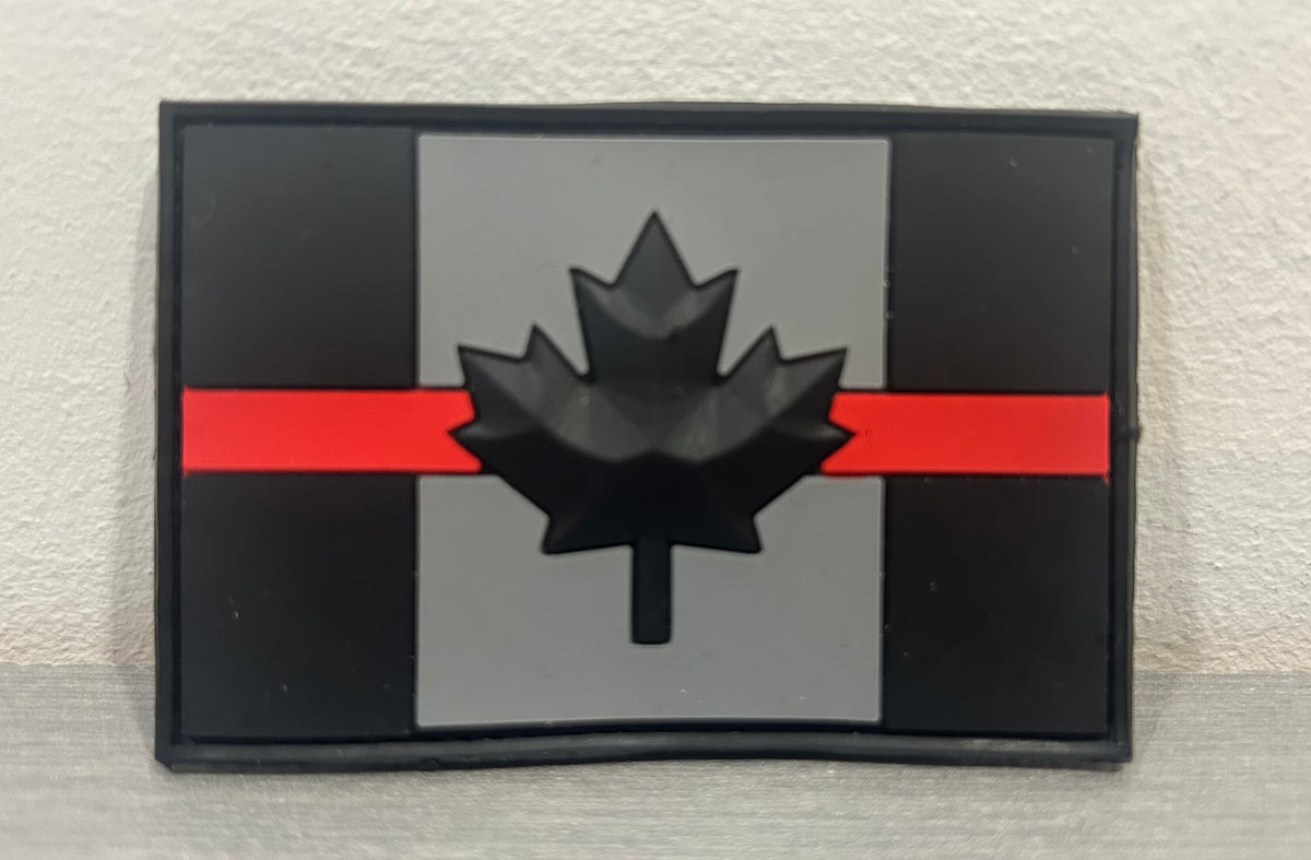 District Airsoft Canada PVC Patch with a black maple leaf on a grey background and red stripe