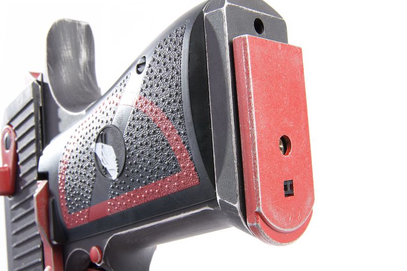 Close-up of the Deadpool airsoft pistol showing red and black design details and textured grip