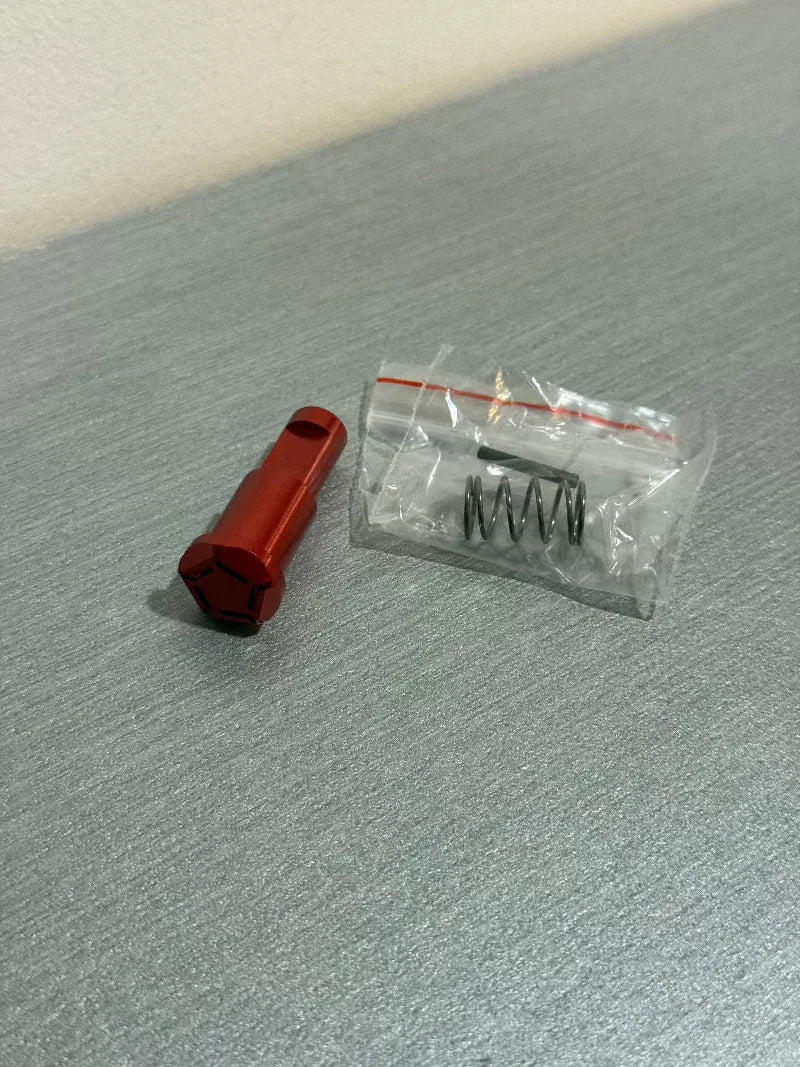 IPSC RED ASSIST BUTTON in red with accompanying spring for quick access features