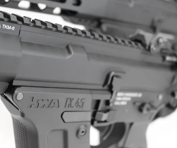 Close-up of KWA RONIN TK45 AEG with detailed markings and rail system for attachments