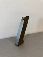 used KWC P226 X-5 CO2 magazine standing upright on a gray surface showing base plate and feed lips