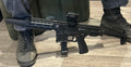 LAMBDA DEFENSE B&T GHM9 COMPACT-G SMG displayed next to a person wearing tactical boots