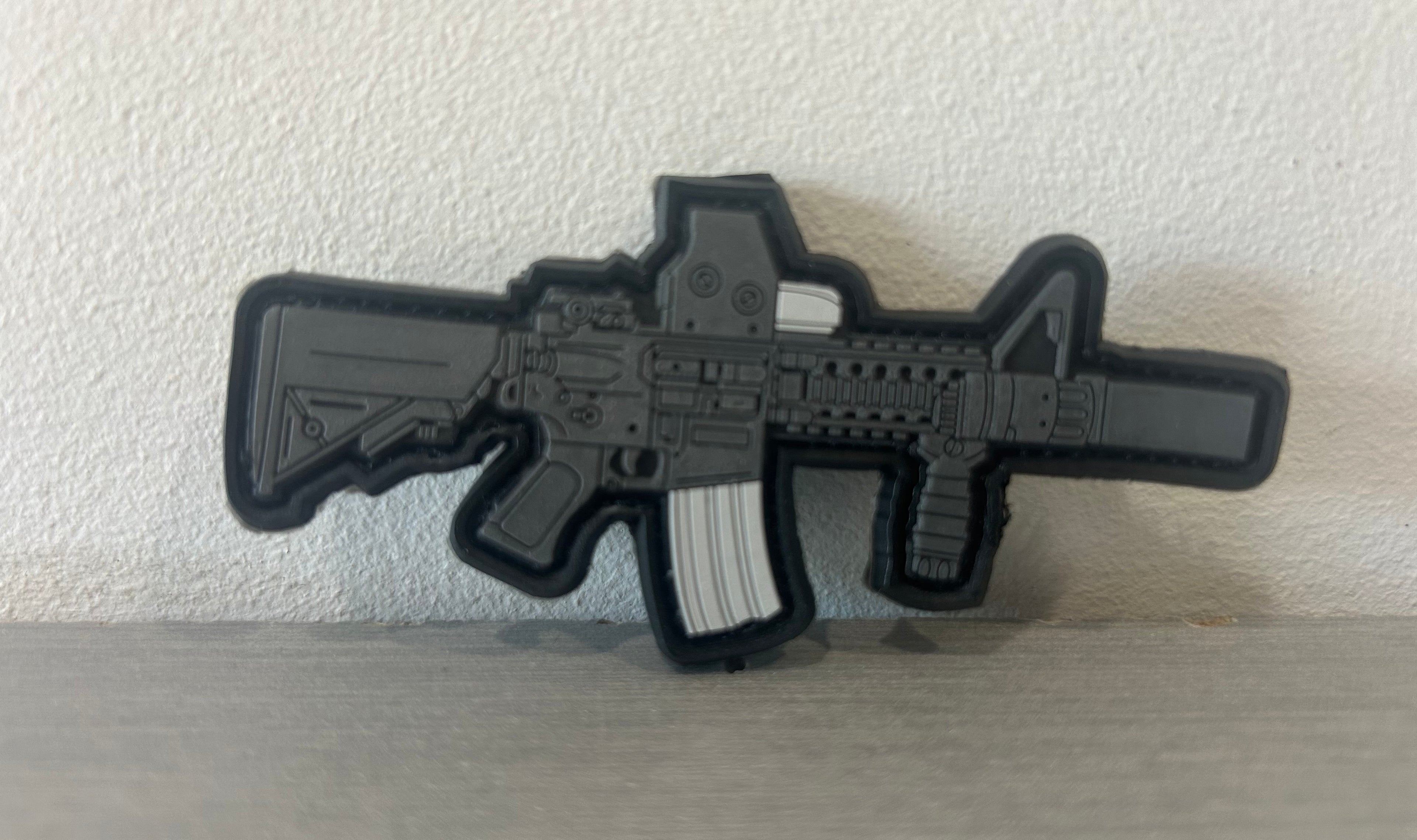 Black and gray PVC M4 patch featuring a detailed rifle design for tactical gear
