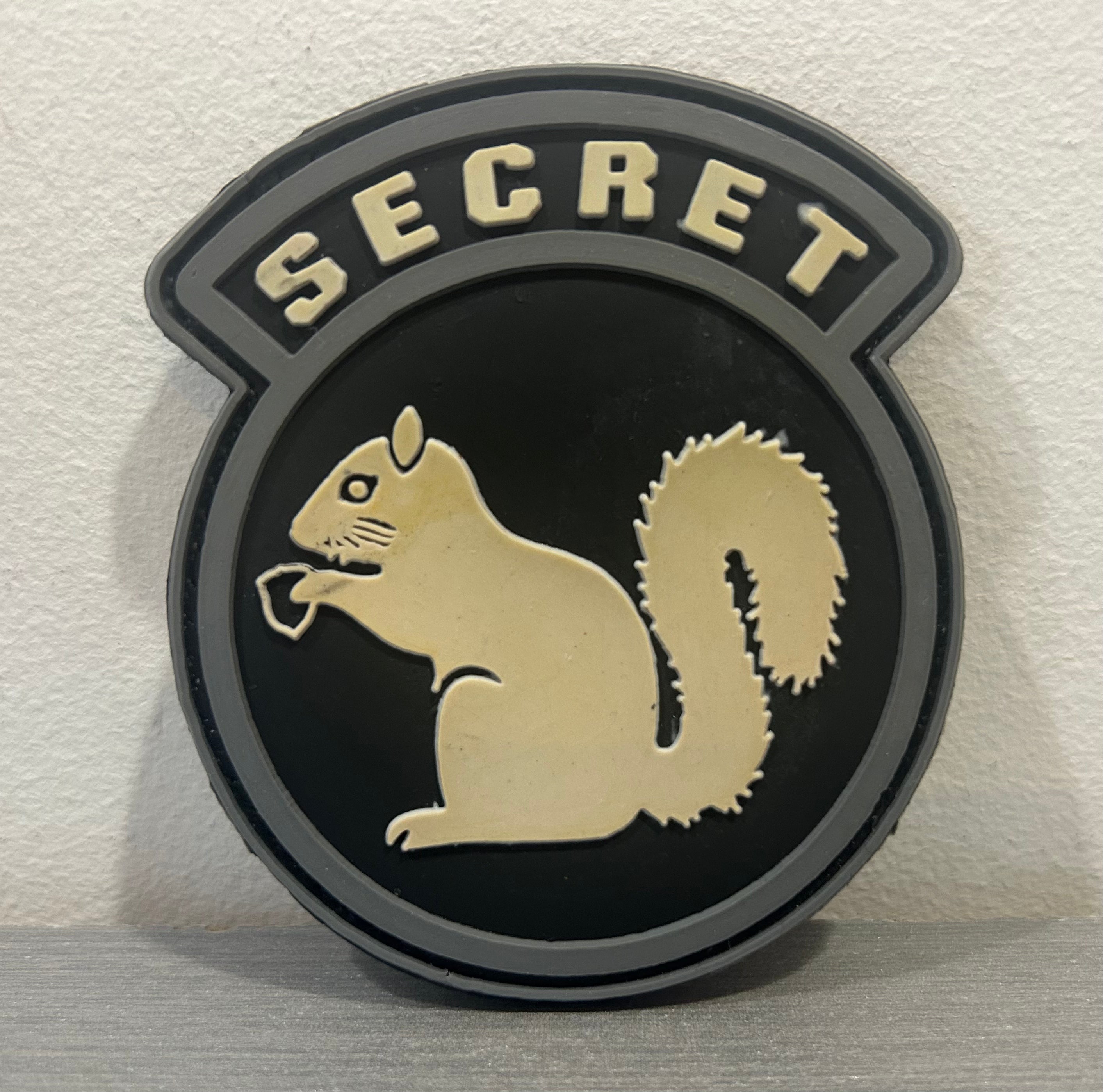 District Airsoft PATCH PVC SECRET featuring a squirrel design on a circular black background
