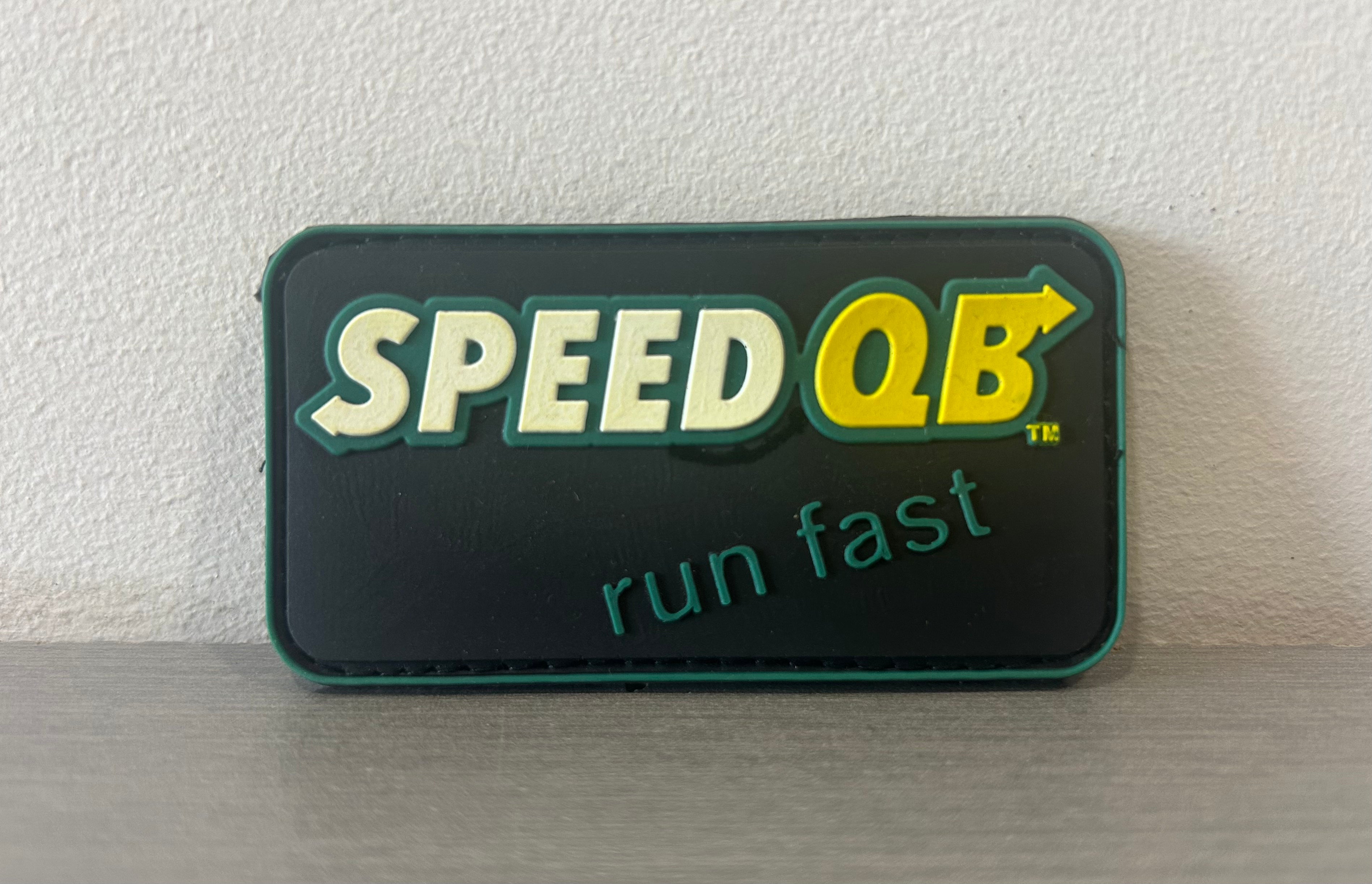 QB PVC PATCH BLACK featuring bold Speed QB logo with a motivational phrase to run fast