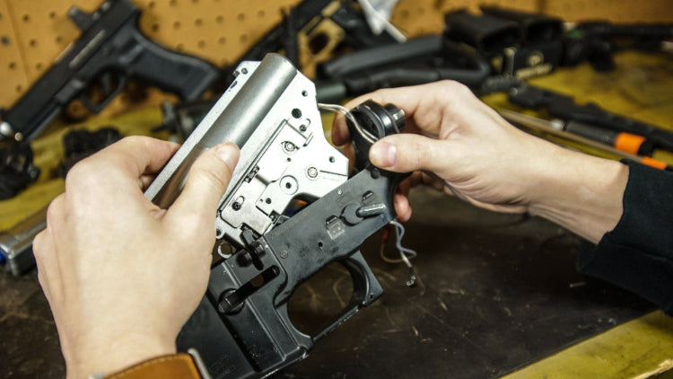 airsoft technicien repairing an aeg rifle replica