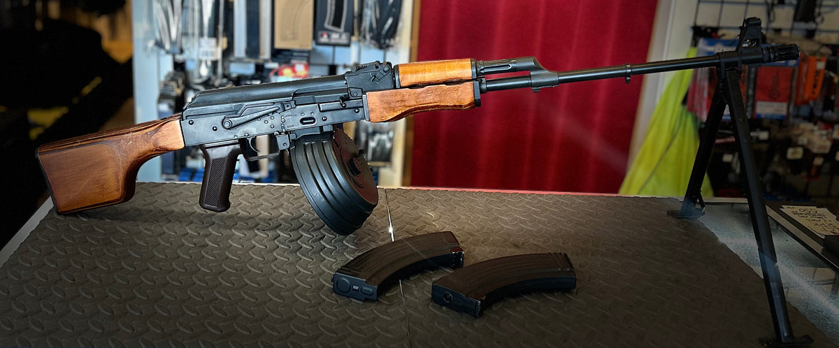 AEG RPK Airsoft Gun with Wooden Stock and Black Magazine on Display at Store