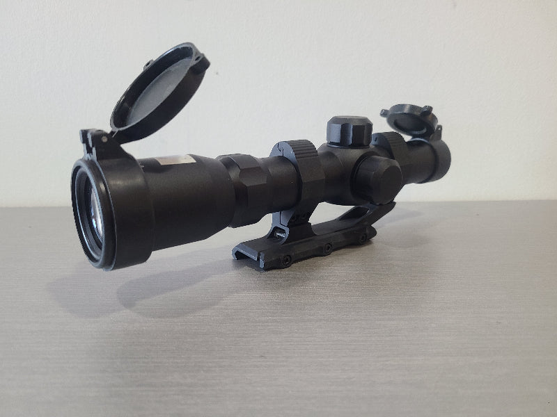 District Airsoft scope 4x24 h18 black rifle accessory with flip-up lens covers on wooden surface