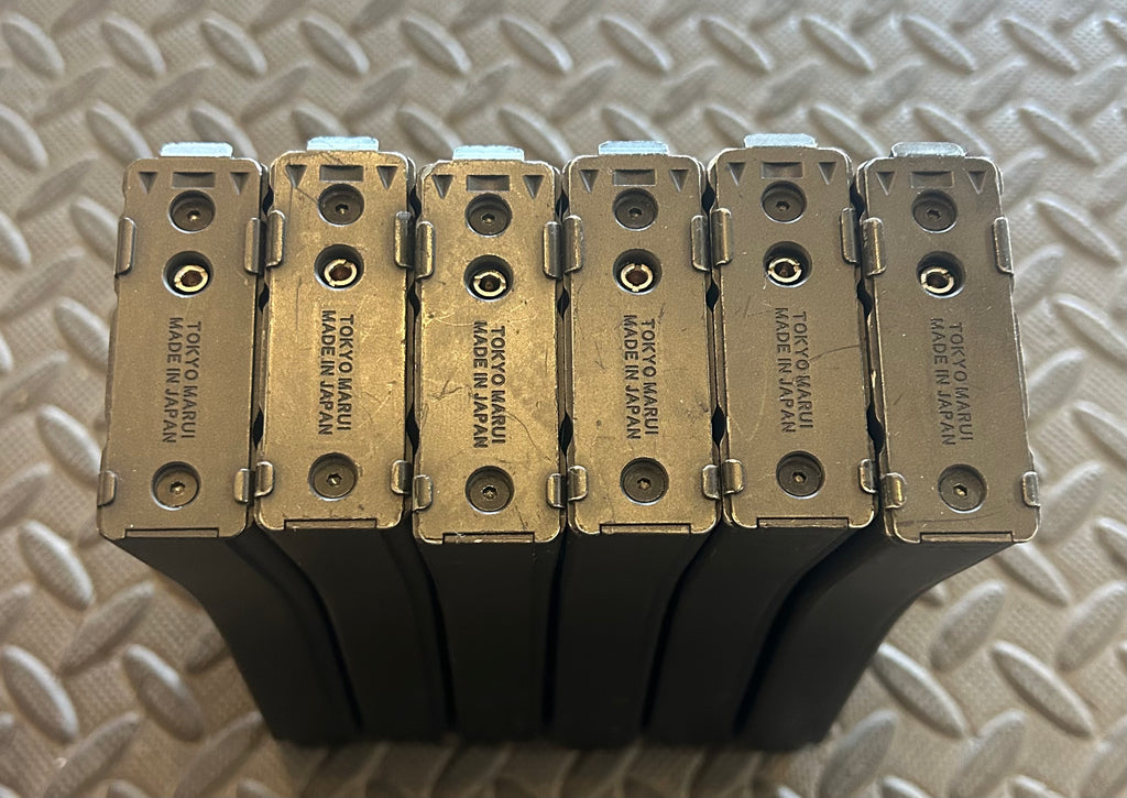 Six Tokyo Marui MWS GBBR mag magazines stacked with metal bases for airsoft enthusiasts