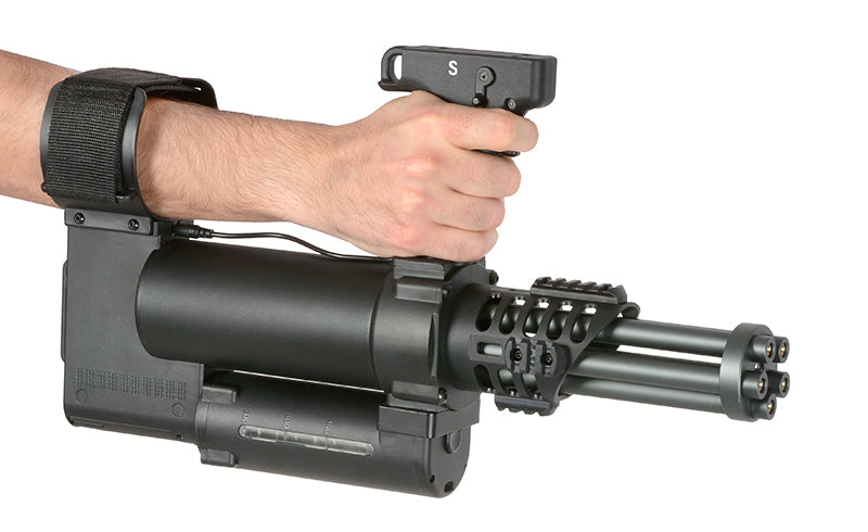 Hand holding WELL PRO MINIGUN AIRSOFT AEG with black grip and rotating barrels in action pose